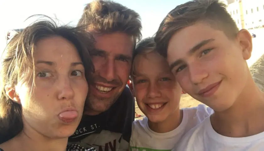 Famiglia in vacanza con ragazzi di 15 anni, sorrisi e sole.
