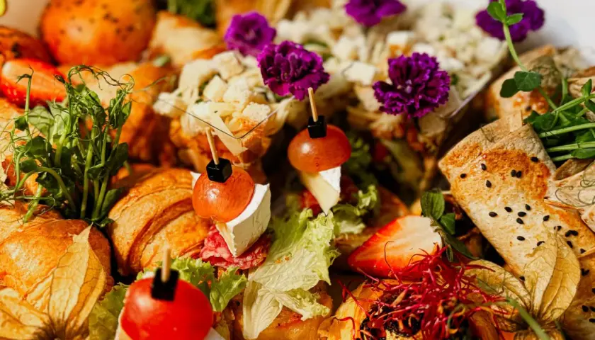 Wykwintne przekąski na 18 urodziny: mini croissanty, tartinki z owocami i serem, zawijane tortille i świeże zioła.