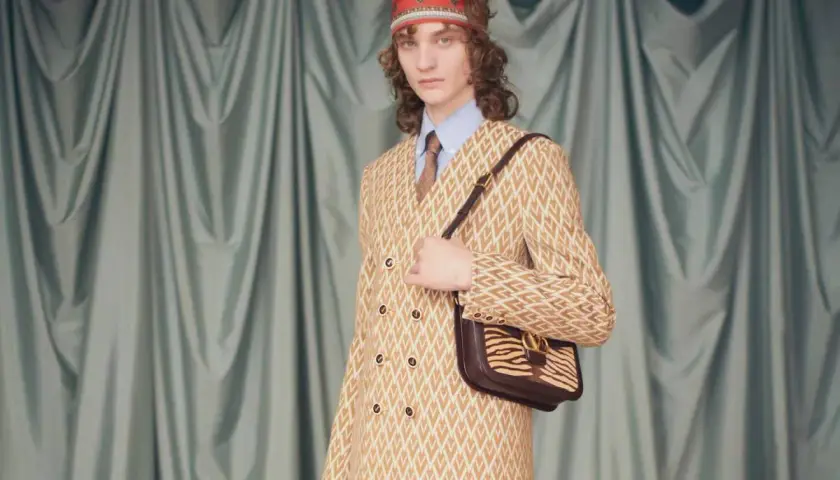 Modelo con traje estampado y bolso de cebra, un look que evoca la audacia de Alessandro Michele.