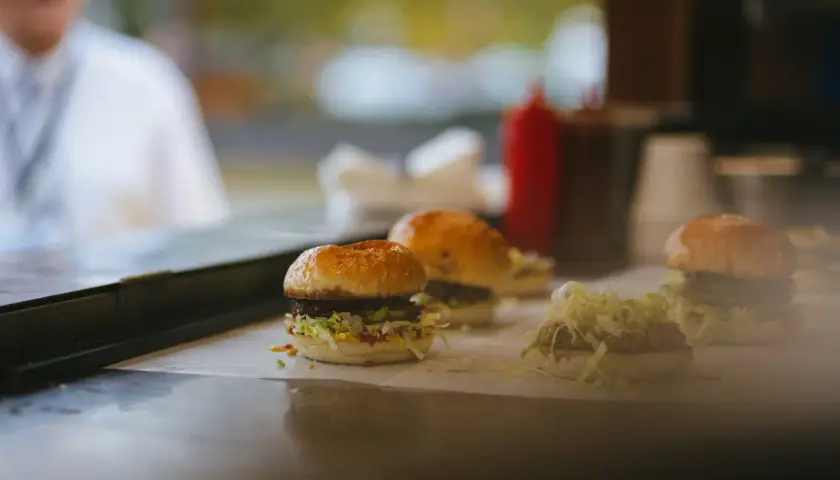 Trzy soczyste burgery, prawdziwe bomby kaloryczne na przytycie, gotowe do podania.