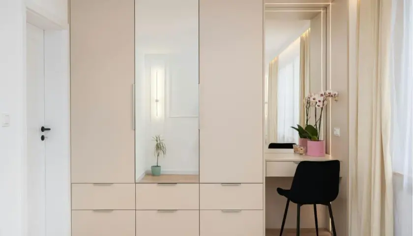 Armadio in laminato chiaro con ante a specchio e zona toeletta. Un modo moderno per rinnovare armadio laminato e creare uno spazio funzionale.
