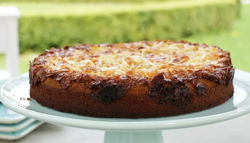 En gyllene tosca kaka med karamelliserade mandlar på en ljusblå tårtfat. Bakad till perfektion för en härlig fika.