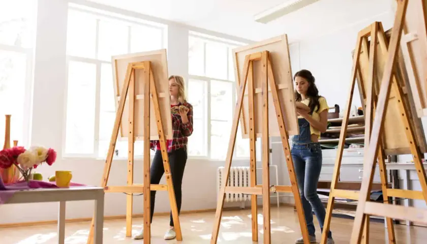Zwei Frauen malen in einem hellen Atelier. Sie stehen vor Staffeleien, die aussehen, als ob sie jemand selber bauen könnte.