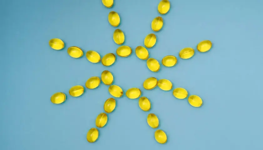 Gelbe Kapseln bilden eine Sonne, die gegen Winterdepression hilft. Vitamin D für mehr Licht.