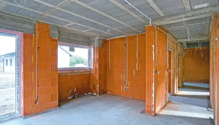 Budowa domu w toku: ściany z pustaków ceramicznych, instalacja elektryczna, okna. Sprawdź nasze usługi elektryczne cennik.
