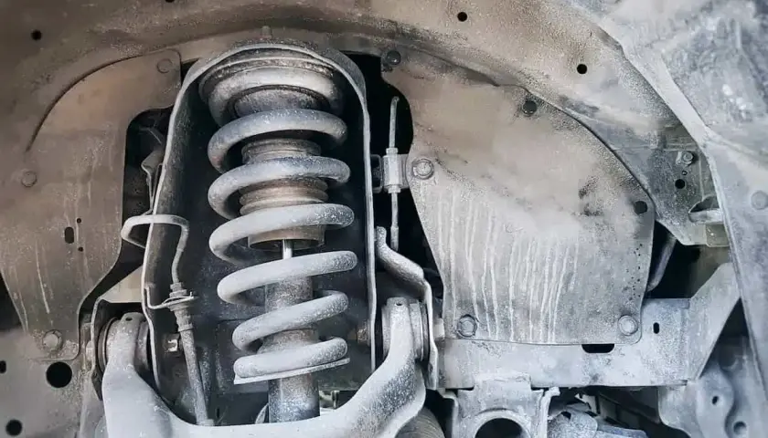 Primer plano de un amortiguador de coche, parte esencial para el confort y la seguridad.