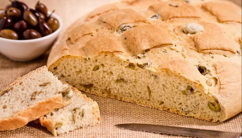 Un delicioso pan italiano con aceitunas, recién horneado y listo para disfrutar.