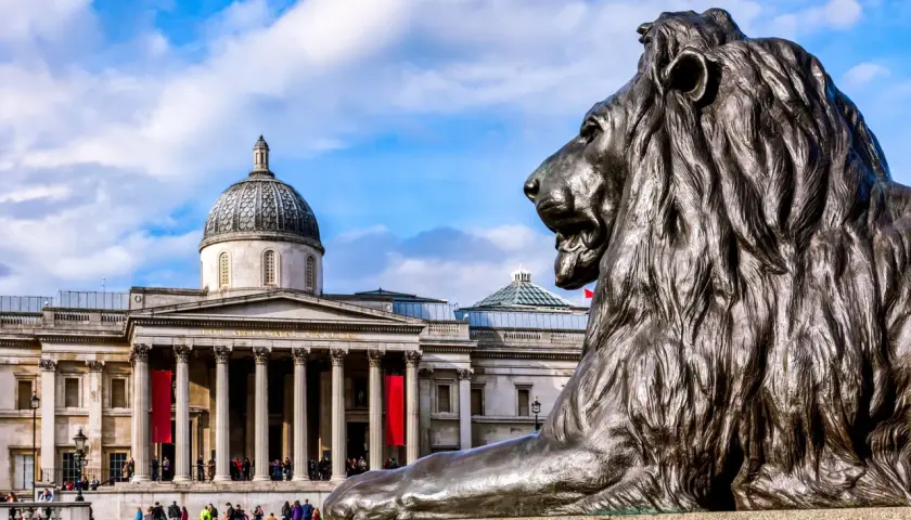 Lew przed monumentalnym budynkiem Muzeum Narodowego w Londynie.
