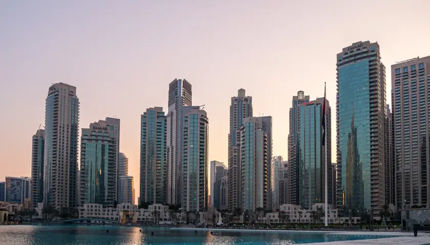 Wieżowce w Dubaju o zachodzie słońca, w tym budynki Emaar. Wspaniałe dubaj atrakcje nad wodą.
