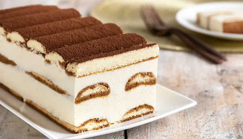 Tiramisù cremoso, uno dei dolci senza glutine perfetti per ogni occasione. Strati di savoiardi e crema, spolverati di cacao.