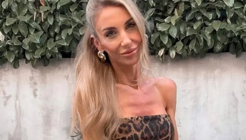 Anna Kolasińska w panterkowej sukience, z burzą blond włosów i złotymi kolczykami, emanuje pewnością siebie.