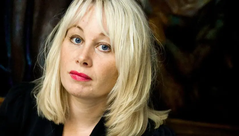 En kvinna med blont hår och blå ögon, med en intensiv blick. Hon representerar mina två liv, det synliga och det dolda.
