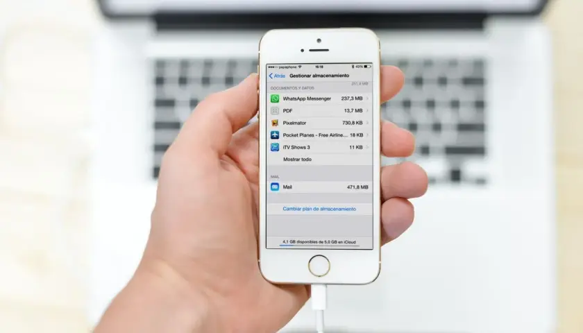 Mano sujetando un iPhone mostrando la gestión de almacenamiento, útil para la copia de seguridad iPhone.