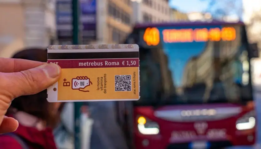 Un biglietto Metrebus Roma da 1,50€, la nuova vitamina del trasporto, pronto per essere usato su un bus rosso in città.