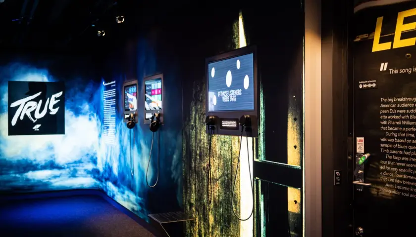 Utställning på Avicii museum med skärmar och hörlurar. En skärm visar texten "IF THOSE LISTENERS WERE EGGS".
