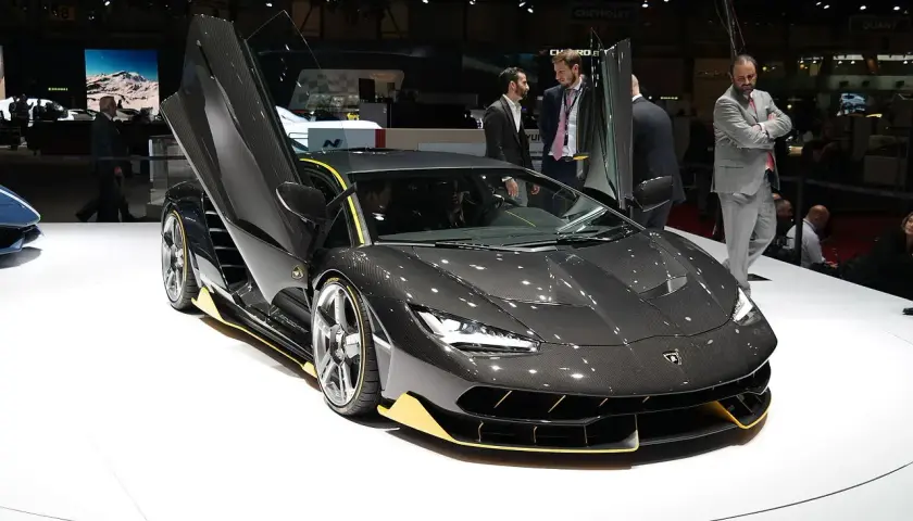 Ciemnoszary Lamborghini z otwartymi drzwiami, żółtymi akcentami. Zastanawiasz się, ile kosztuje Lamborghini? Ten model robi wrażenie!