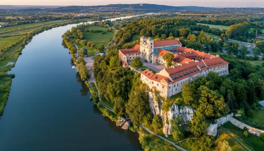 Opactwo Benedyktynów w **Tieńcu** majestatycznie wznosi się nad Wisłą, otoczone zielenią.