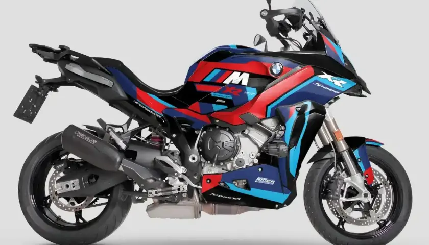 Moto BMW S1000XR con livrea M sportiva e accattivante. Gli stemmi moto sono ben visibili, con dettagli rossi, blu e bianchi su sfondo blu scuro.