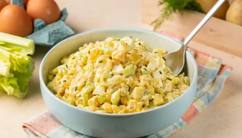 Deliciosa ensalada de apio y manzana, cremosa y fresca, con trozos de huevo duro y patata.