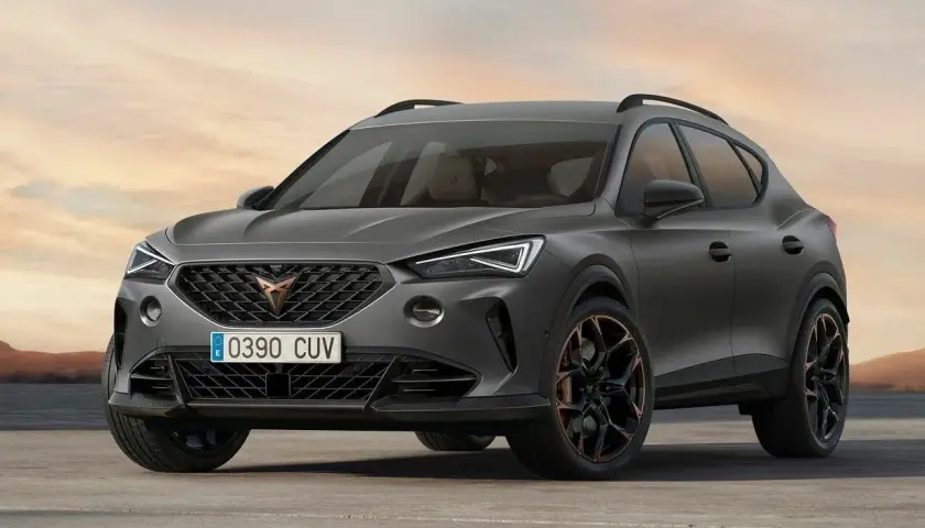 Stylowe, ciemnoszare auto Cupra z miedzianymi akcentami na felgach, zaparkowane na pustkowiu o zachodzie słońca.