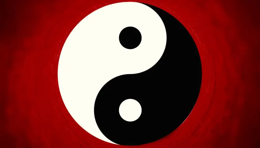 Il simbolo Yin e Yang, principio della filosofia orientale, su sfondo rosso sfumato.