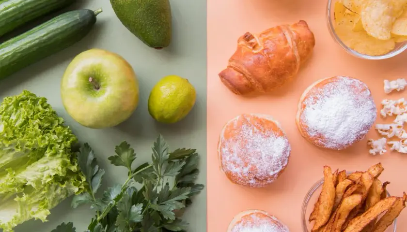 Złe węglowodany: pączki, croissant, frytki, chipsy i popcorn kontra zdrowe warzywa i owoce: ogórki, awokado, jabłko, cytryna, sałata i pietruszka.