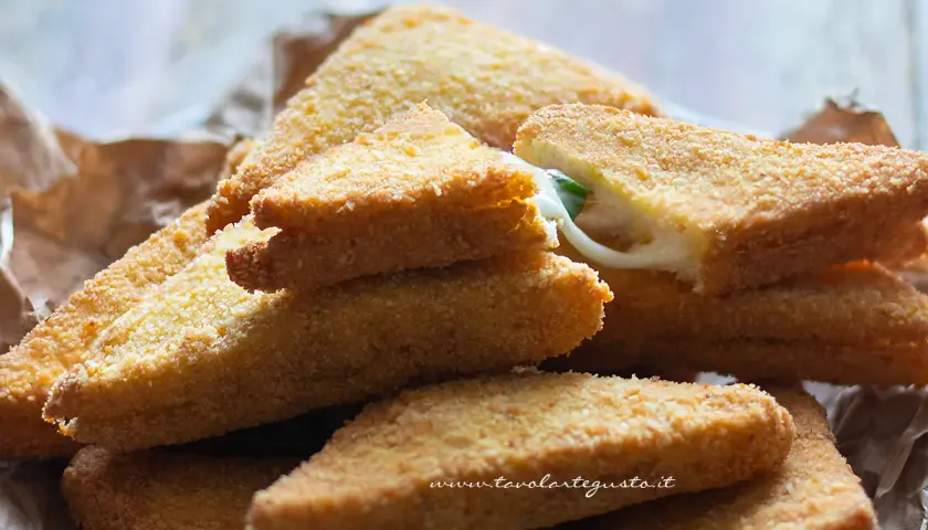 Mozzarella in carrozza dorate e croccanti, con il formaggio filante che fuoriesce da una fetta.