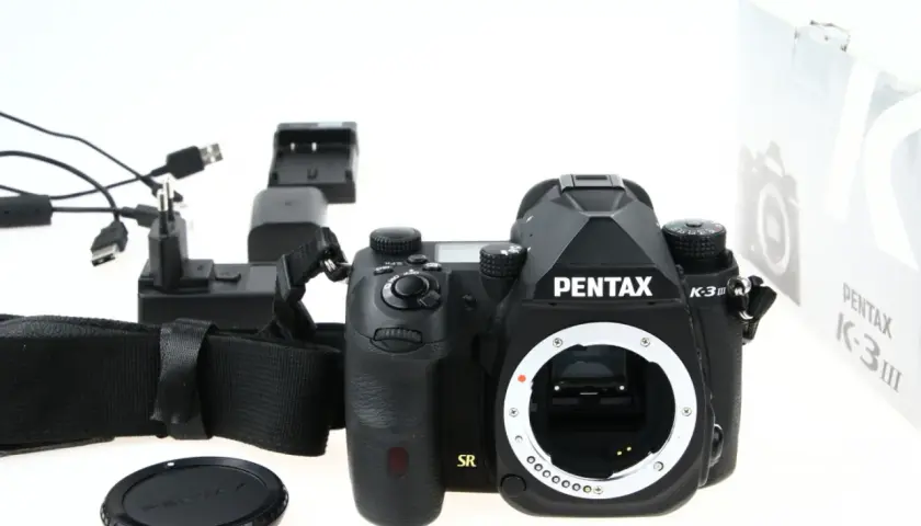 Czarny aparat Pentax K-3 III, ładowarka i akcesoria. Czy to lustrzanka czy bezlusterkowiec?