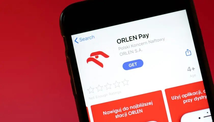 Aplikacja ORLEN Pay na ekranie telefonu. Umożliwia nawigację do stacji ORLEN i płatności.