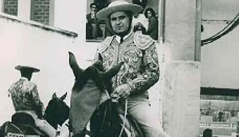 Toreros rubios, con trajes de luces bordados, montan a caballo. Uno de ellos, en primer plano, mira fijamente.