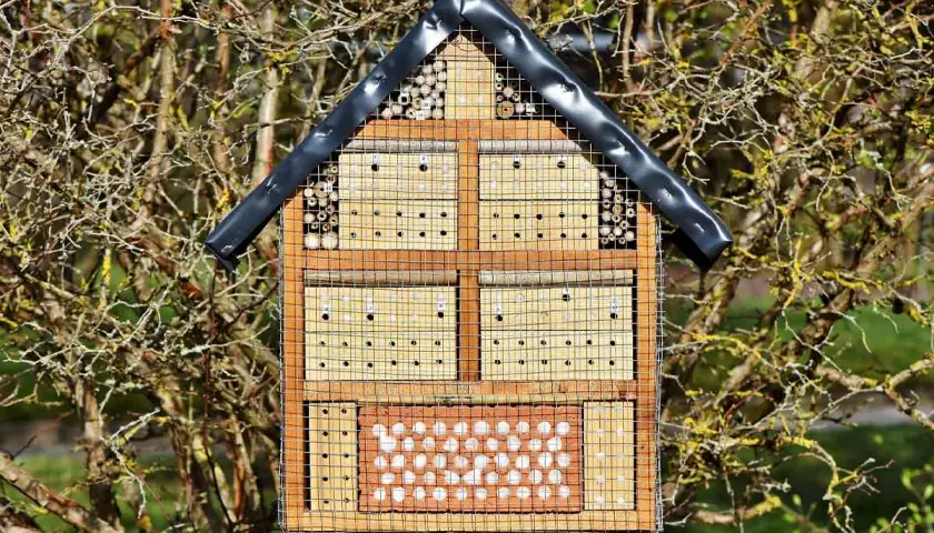 Ein Insektenhotel mit verschiedenen Fächern für Nützlinge, ideal als Standort im Garten.