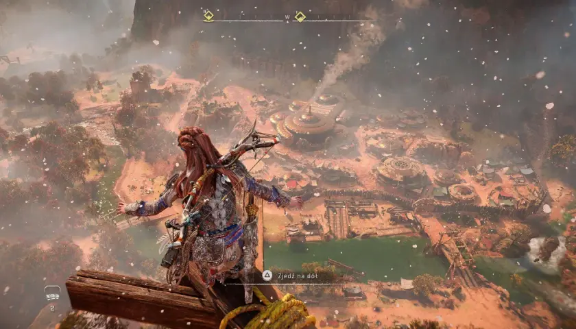 Aloy z Horizon Zero Dawn 2 spogląda na osadę z góry. W tle widać górzysty krajobraz i mgłę.