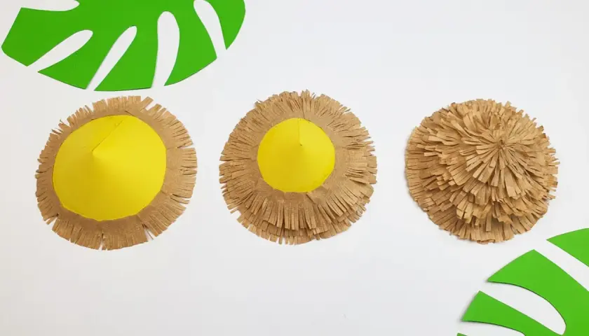 Schritt-für-Schritt-Anleitung zum **sonnenschirm basteln**: Gelbe Kegel mit braunen Fransen werden zu einem tropischen Sonnenschirm.