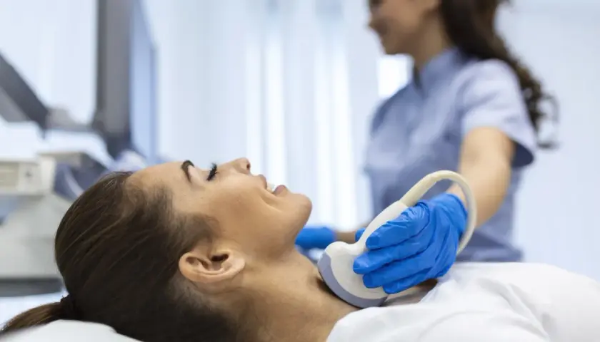 Badanie USG szyi, kluczowe dla diagnostyki tarczycy. Lekarz wykonuje badanie, by ocenić stan tarczycy, a jod jest ważnym pierwiastkiem dla jej prawidłowego funkcjonowania.