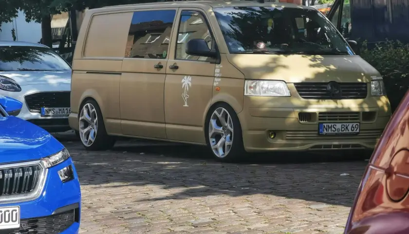 Złoty bus, przeróbka busa na kampera przepisy. Stylowe felgi i naklejki dodają mu charakteru.