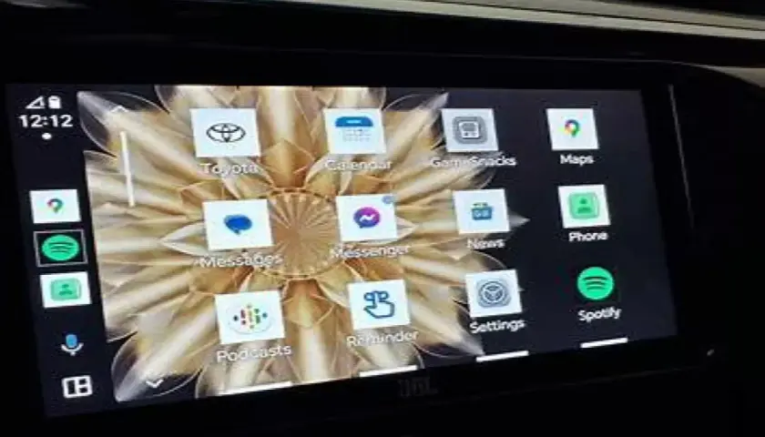 Ekran samochodu z aplikacją Android Auto. Widoczne ikony: Toyota, Kalendarz, Gry, Mapy, Wiadomości, Telefon, Spotify, Ustawienia, Podcasty, Przypomnienia, Messenger.