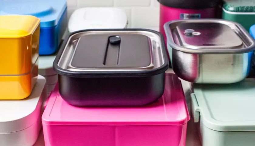 A colorful assortment of various types of bento boxes, including stainless steel, plastic, and stacked designs, ready for a delicious meal.