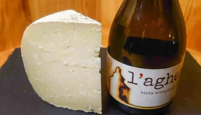 Un pezzo di formaggio stagionato accanto a una bottiglia di birra artigianale. Attenzione, il tomino fa ingrassare!