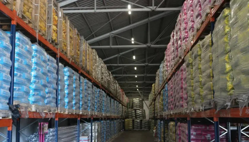Magazyn Atex Pilchowice z ekogroszkiem i innymi produktami na paletach. Rzędy worków w foliowych opakowaniach.