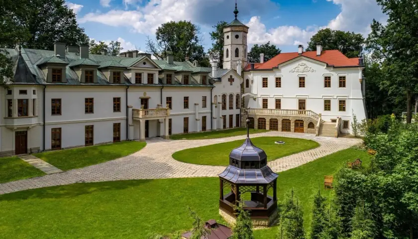Pałac w Nawojowej z wieżą i altaną na dziedzińcu.