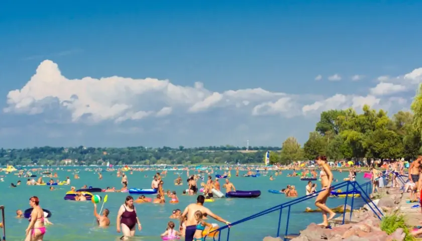 Tłumy ludzi kąpią się i relaksują nad wodą, szukając ochłody. Wszyscy zastanawiają się, gdzie nad Balaton, by cieszyć się słońcem i zabawą.