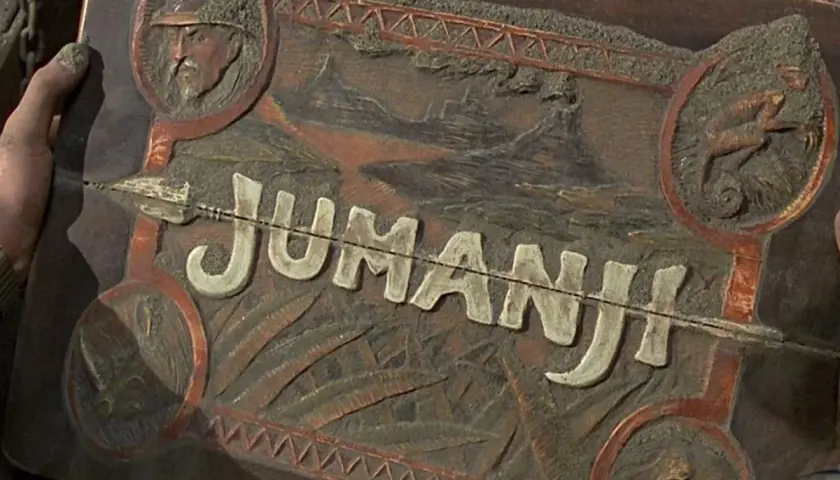 Drewniana skrzynka z napisem "JUMANJI" i reliefami zwierząt, przypominająca rekwizyty z filmów Jumanji.