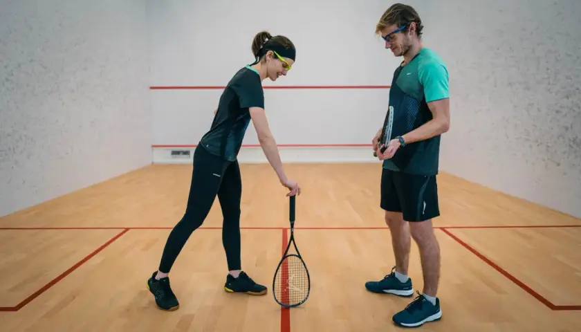 Para, która omawia zasady squash serwisu na korcie.