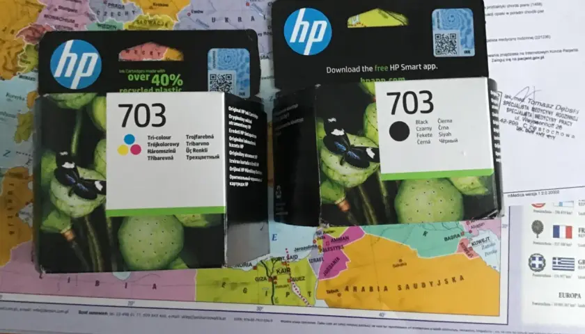 HP 703 to numer tuszu. Na opakowaniu widać logo HP i motyw kwiatowy.