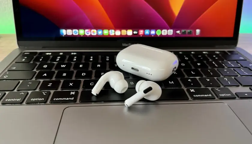 AirPods i etui na klawiaturze MacBooka. Dowiedz się, jak podłączyć AirPods do laptopa, aby cieszyć się bezprzewodowym dźwiękiem.