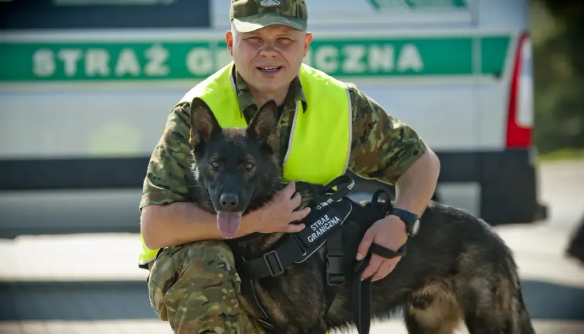 Funkcjonariusz Straży Granicznej z psem, który pomaga w pracy. Psy pracujące to wierni towarzysze na służbie.