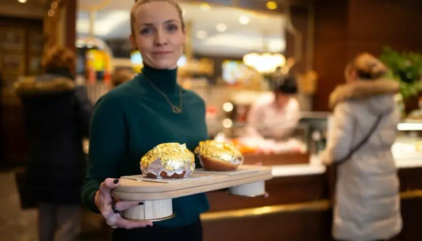Elegancka piekarnia po francusku prezentuje dwa pączki w płatkach złota.