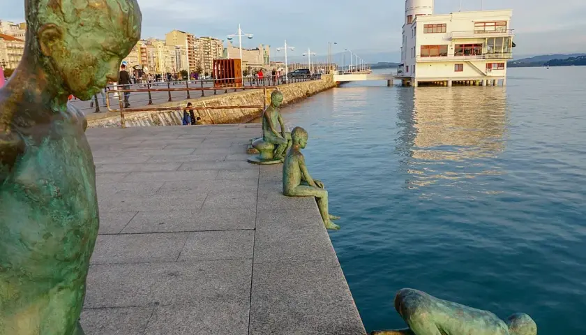 Los raqueros, esculturas de bronce, observan el mar desde el paseo marítimo. Uno se lanza al agua, otro espera sentado.