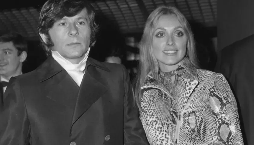 Roman Polański i jego żona Sharon Tate, uśmiechnięci, pozują do zdjęcia.