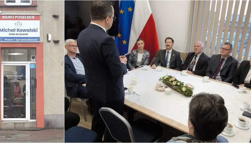 Biuro poselskie Michała Kowalskiego. Spotkanie przy stole z flagami Polski i UE.
